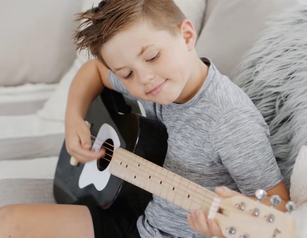 a boy playing guitar happily